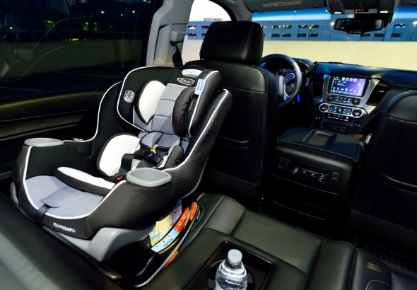Мама пристібає малюка в дитячому автокріслі в салоні автомобіля